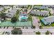 Aerial view featuring a community pool, tennis courts, and ample parking at 455 Alt 19 S # 65, Palm Harbor, FL 34683