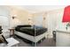 Sunny bedroom with a metal bed frame and neutral walls, plus bedside lighting at 455 Alt 19 S # 65, Palm Harbor, FL 34683