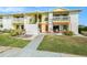Yellow and white condo with a small patio area accessible from the main floor at 455 Alt 19 S # 65, Palm Harbor, FL 34683