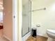 Tiled bathroom featuring a glass shower, toilet, and trash can at 503 Finsbury Cir # A, Sun City Center, FL 33573