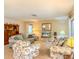 Comfortable living area with floral armchairs, neutral sofa, and entertainment center at 503 Finsbury Cir # A, Sun City Center, FL 33573