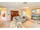 Bright living room featuring soft blue sofa, floral armchair, and a wood entertainment center at 503 Finsbury Cir # A, Sun City Center, FL 33573