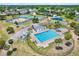 Aerial view of community pool, tennis courts, playground, and recreational facilities surrounded by lush greenery at 5137 Springwood Dr, Tampa, FL 33624