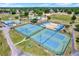 Aerial view of the community's tennis and basketball courts, and recreational facilities amidst green spaces at 5137 Springwood Dr, Tampa, FL 33624