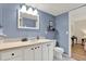 Well-lit bathroom with a stylish vanity, a toilet, and fresh, pale blue paint at 5137 Springwood Dr, Tampa, FL 33624