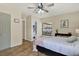 Comfortable bedroom features wood floors, a ceiling fan, and a view of the fenced patio at 5137 Springwood Dr, Tampa, FL 33624
