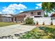 Home featuring solar panels, fenced yard, and a paved driveway at 5137 Springwood Dr, Tampa, FL 33624