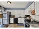 Well-lit kitchen with stainless steel appliances, granite counters, and stylish white cabinets at 5137 Springwood Dr, Tampa, FL 33624