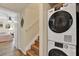 Convenient laundry area with a modern stacked washer and dryer near the stairway at 5137 Springwood Dr, Tampa, FL 33624