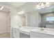 Well-lit bathroom with double vanity sinks, a large mirror, and a walk-in closet at 5194 Everlong Dr, Apollo Beach, FL 33572