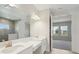 Bright bathroom with double vanity sinks, a large mirror, and a partial view into a bedroom at 5194 Everlong Dr, Apollo Beach, FL 33572