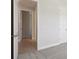 Open hallway with white trim and hardwood flooring leading into carpeted bedroom at 5194 Everlong Dr, Apollo Beach, FL 33572
