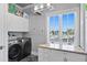 Bright laundry room with granite countertops, washer, dryer, and a large window at 5939 Bayview S Cir, Gulfport, FL 33707