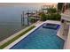 Beautiful waterfront backyard featuring a sparkling pool and jacuzzi with travertine and artificial turf at 5939 Bayview S Cir, Gulfport, FL 33707
