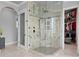 A luxury stone shower features a rainfall shower head and glass enclosure, adjacent to a walk-in closet at 5939 Bayview S Cir, Gulfport, FL 33707