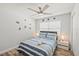 Bright bedroom features wood-look floors, ceiling fan, nautical decor, and a sunny window at 6428 Moss Way, Tampa, FL 33625