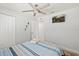 Bright bedroom featuring a ceiling fan, TV, coastal decor, and comfortable striped bedding at 6428 Moss Way, Tampa, FL 33625