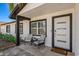 Inviting porch features modern door, stylish chairs, and a welcoming doormat that says 