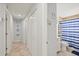 Hallway leading to bathroom with coastal wall decor and a view of the bath and shower combo at 6428 Moss Way, Tampa, FL 33625