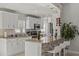 Charming kitchen features white cabinets, granite counters, tile backsplash and breakfast bar with seating at 6428 Moss Way, Tampa, FL 33625