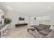 Bright living room features tile floors, gray couch, mounted TV, and view to front door and entry at 6428 Moss Way, Tampa, FL 33625