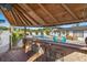 View of outdoor bar area overlooking the pool and patio with chairs, complete with bar stools and a covered deck at 6428 Moss Way, Tampa, FL 33625