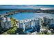 Stunning aerial view of a waterfront condo building with beautiful landscaping, a bridge, and blue water views at 7882 Sailboat Key S Blvd # 401, South Pasadena, FL 33707
