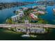 Stunning aerial view of waterfront condominium complex, with bridge access, marina, and lush landscaping at 7882 Sailboat Key S Blvd # 401, South Pasadena, FL 33707