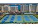 Aerial view of community tennis courts with players and well-maintained blue and green surfaces at 7882 Sailboat Key S Blvd # 401, South Pasadena, FL 33707