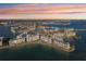 Breathtaking aerial view of waterfront condos with boat docks and city skyline at sunset at 7912 Sailboat Key S Blvd # 508, South Pasadena, FL 33707