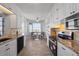 Modern kitchen with white cabinets, granite countertops, stainless steel appliances, and a quaint dining area at 7912 Sailboat Key S Blvd # 508, South Pasadena, FL 33707
