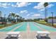 Community shuffleboard courts framed by tropical landscaping and benches with condos in the background at 7912 Sailboat Key S Blvd # 508, South Pasadena, FL 33707