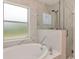 Modern bathroom featuring a glass enclosed shower, a soaking tub and marble-look tile at 8561 Deer Chase Dr, Riverview, FL 33578