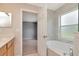 Bathroom with a soaking tub next to a window; the main bedroom is visible through a doorway at 8561 Deer Chase Dr, Riverview, FL 33578