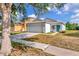 Charming single-story home featuring a well-maintained lawn, two-car garage and quaint front porch and an inviting turquoise door at 8561 Deer Chase Dr, Riverview, FL 33578