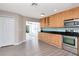 Bright kitchen featuring stainless steel appliances, black counters, and light wood cabinets at 8561 Deer Chase Dr, Riverview, FL 33578