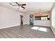 Bright living room with neutral walls, vaulted ceiling, ceiling fan, luxury vinyl plank flooring, and pass through to kitchen at 8561 Deer Chase Dr, Riverview, FL 33578