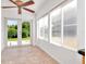 Sunroom with tile floor and multiple windows looking out to green yard and landscaping at 8561 Deer Chase Dr, Riverview, FL 33578