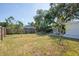 Spacious backyard featuring a lush lawn, mature trees, and a wooden fence for privacy at 9118 108Th Ave, Seminole, FL 33777