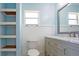 Bright bathroom featuring floating shelves, a toilet, vanity with drawers, and a mirror at 9118 108Th Ave, Seminole, FL 33777