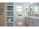 Bright bathroom featuring floating shelves, a toilet, vanity with drawers, and a mirror at 9118 108Th Ave, Seminole, FL 33777