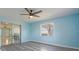 Bright bedroom with ceiling fan, gray flooring, and sliding door access at 9118 108Th Ave, Seminole, FL 33777