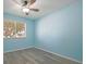 Empty bedroom with blue walls, a ceiling fan, and views through the window at 9118 108Th Ave, Seminole, FL 33777