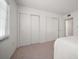 Bright bedroom featuring neutral carpet and ample closet space with sliding doors at 919 Osceola Rd # 202, Belleair, FL 33756