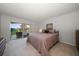 Bright bedroom with a large bed, neutral tones, and sliding doors to the outdoor patio at 919 Osceola Rd # 202, Belleair, FL 33756