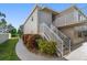 The exterior features well-maintained landscaping and access stairs to upper-level units at 919 Osceola Rd # 202, Belleair, FL 33756