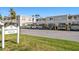 Broadmoor Villas condo exterior view showcasing covered parking, tropical landscaping, and well-maintained facade in a bright, sunny setting at 919 Osceola Rd # 202, Belleair, FL 33756