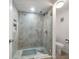 Modern shower with tile surround, glass door, and convenient shelving at 919 Osceola Rd # 202, Belleair, FL 33756