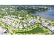 Overhead view of a residential area by a lake, featuring homes, green trees, and neighborhood streets at 1134 Tracey Ann Loop, Seffner, FL 33584