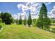 Expansive backyard bordering a serene pond, enhanced by mature trees and green grass at 1134 Tracey Ann Loop, Seffner, FL 33584
